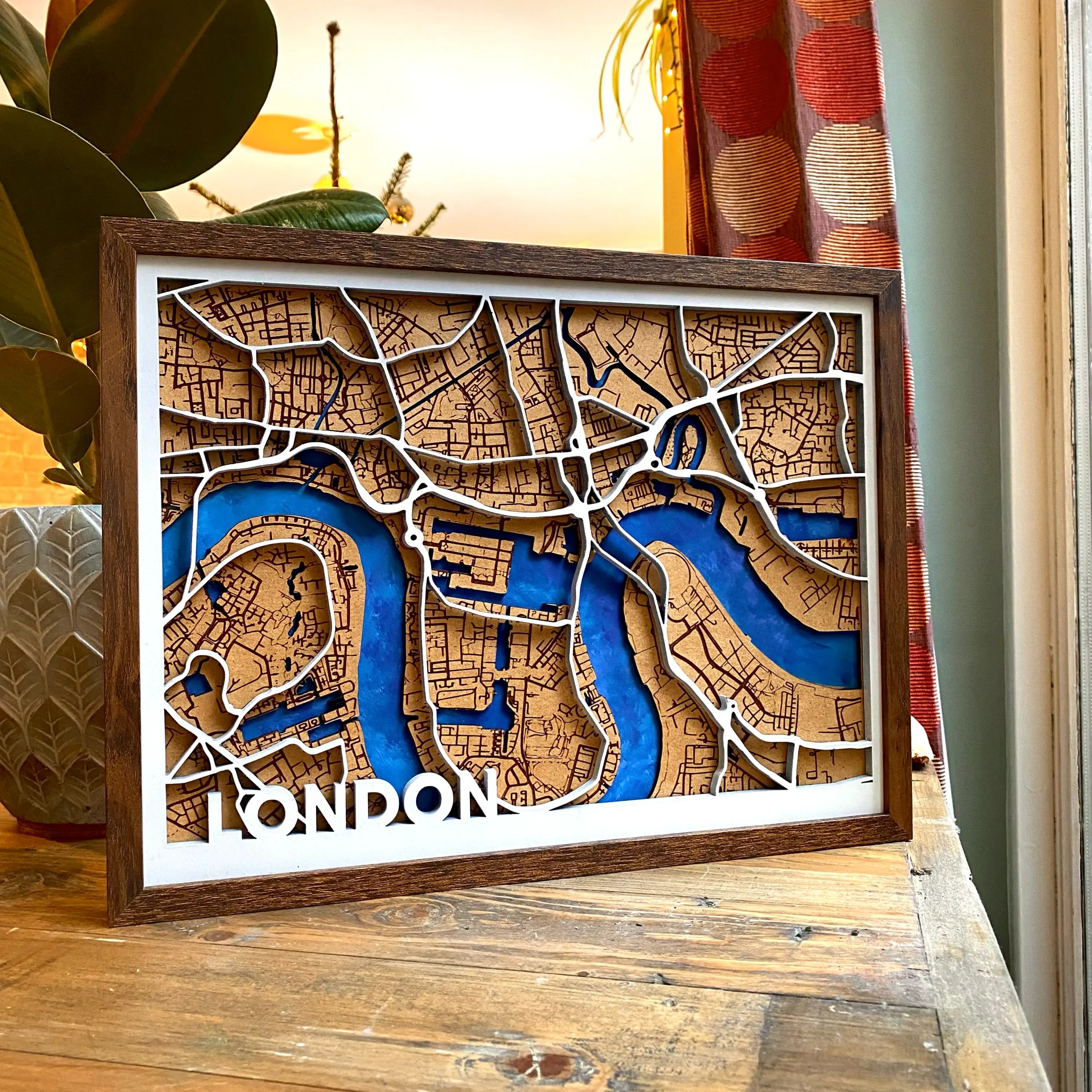 An overall photo of our handmade wooden map of London in a dark birch frame.
