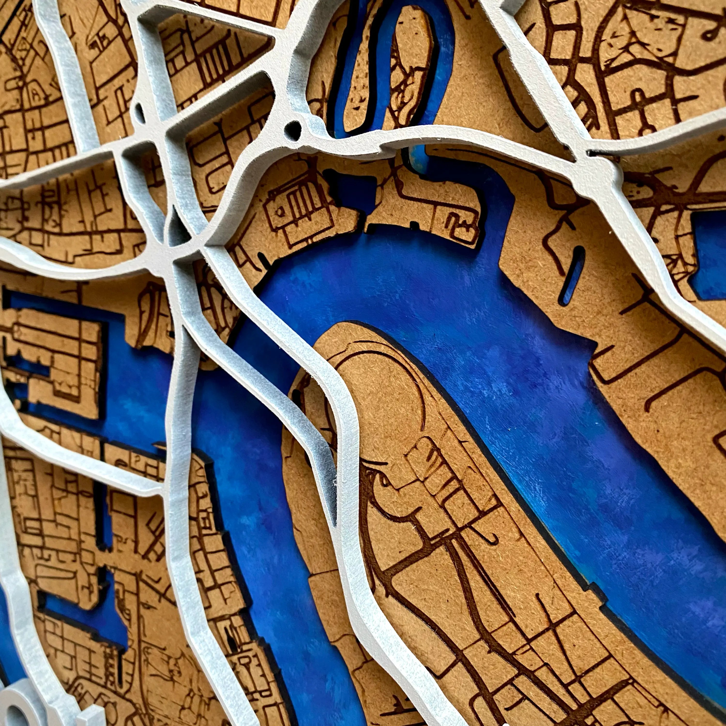 a close up of the white motorways/highways and arterial roads of London on our wooden map
