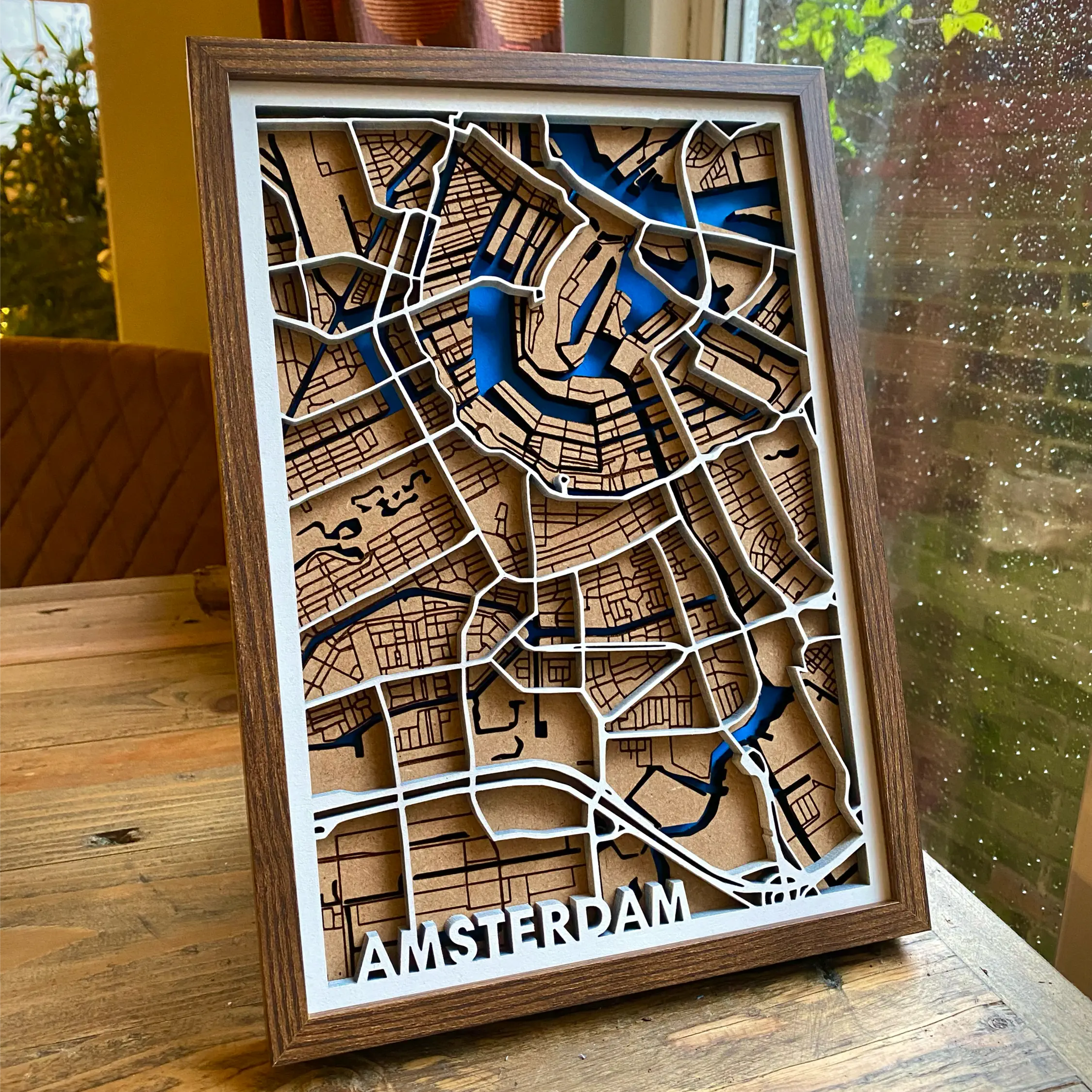 One of our vertical wooden maps featuring white painted arterial/motorway roads and city name tag as the top layer, local roads and streets in brown as the second/middle layer and paint blue waterways/canals/rivers on the third/bottom layer